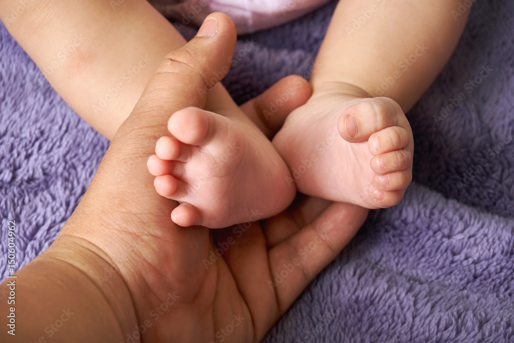 Tiny feet baby in mother hand closeup.concept love of family.Happy Family concept Tiny feet baby in mother hand closeup.concept love of family.Happy Family concept
