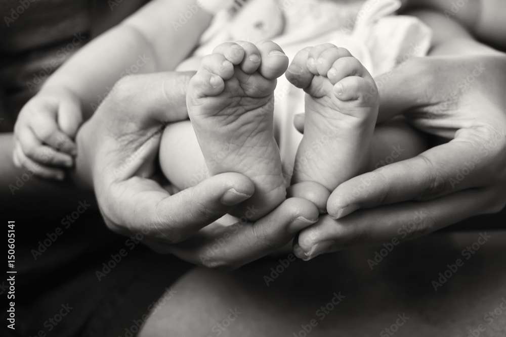 feet baby in mother hands.concept love of family.Happy Family concept.Black and white photo