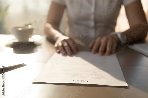 Photo Woman sitting at the desk with loan agreement form