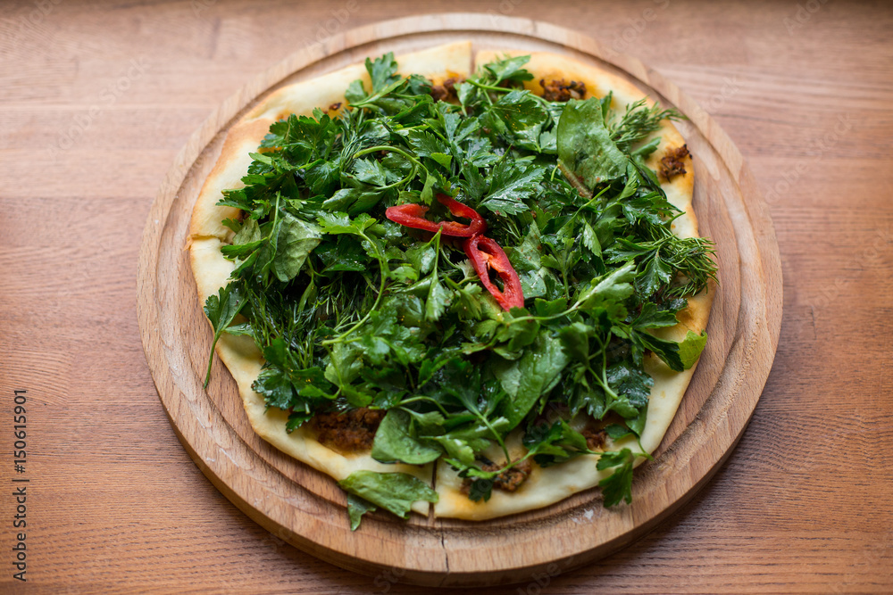Thin armenian pita bread with cheese, pepper and herbs for backing. Lamadjo on a plate. Close up. top view Thin armenian pita bread with cheese, pepper and herbs for backing. Lamadjo on a plate. Close up. top view