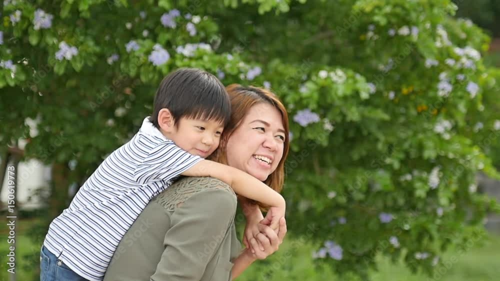 Happy Asian child hugging his mother from behind in the park,slow motion1 Happy Asian child hugging his mother from behind in the park,slow motion1