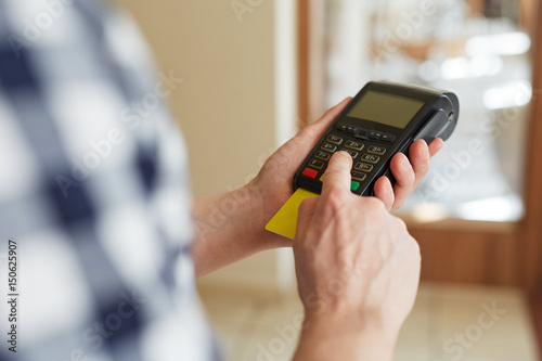 Man entering PIN number using payment terminal