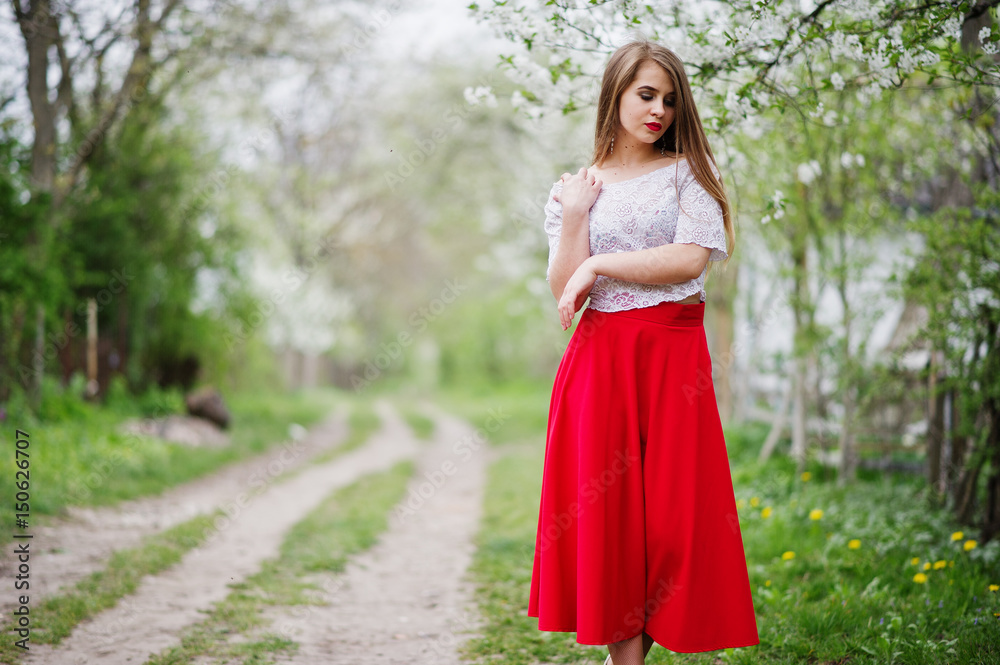 Portrait of beautiful girl with red lips at spring blossom garden, wear on red dress and white blouse. Portrait of beautiful girl with red lips at spring blossom garden, wear on red dress and white blouse.