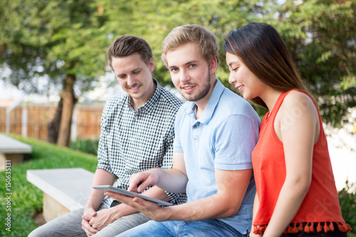 Modern student showing his project to groupmates photo