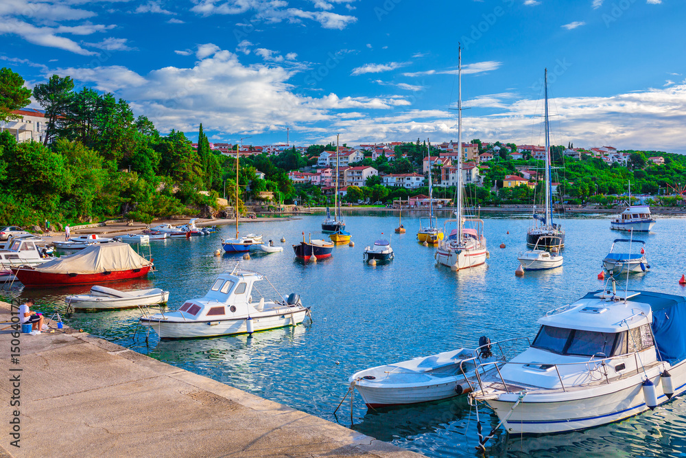 Wonderful romantic summer evening landscape panorama coastline Adriatic sea. Boats and yachts in harbor at cristal clear azure water. Old town of Krk on the island of Krk. Croatia. Europe.