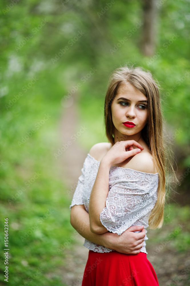 Portrait of beautiful girl with red lips at spring blossom garden, wear on red dress and white blouse. Portrait of beautiful girl with red lips at spring blossom garden, wear on red dress and white blouse.