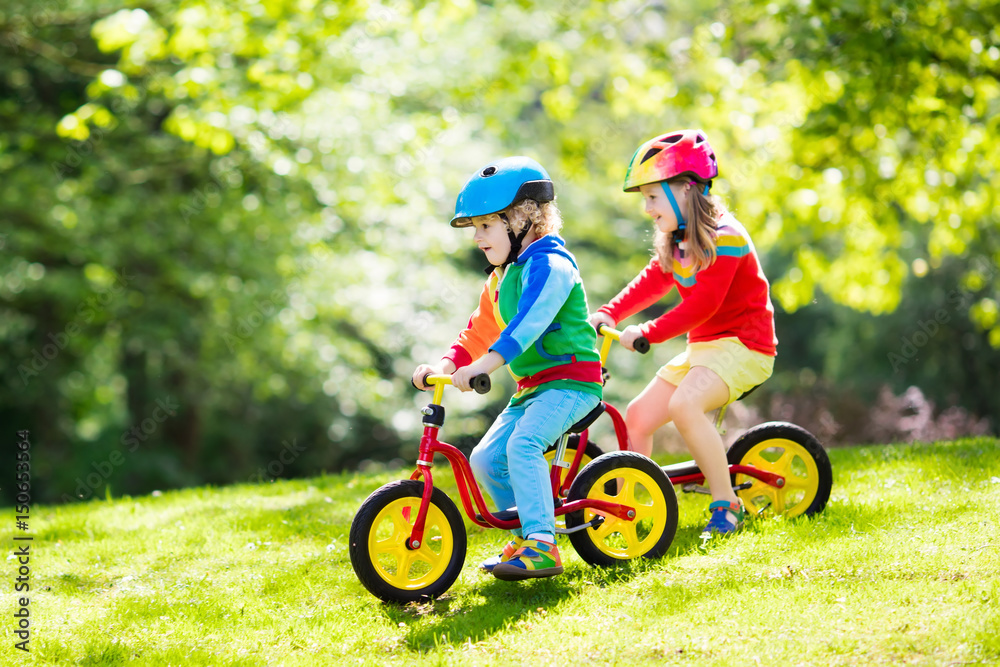 Fototapeta premium Kids ride balance bike in park