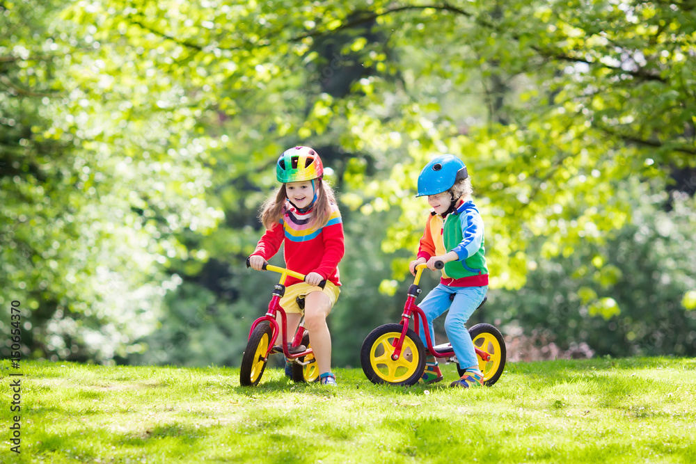 Kids ride balance bike in park Kids ride balance bike in park