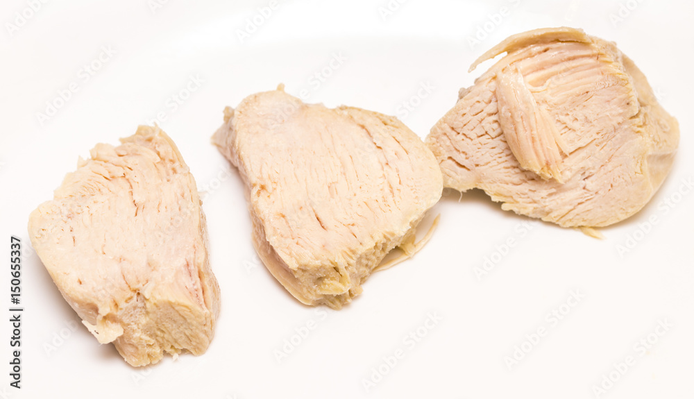 Pieces of boiled chicken breast over white background