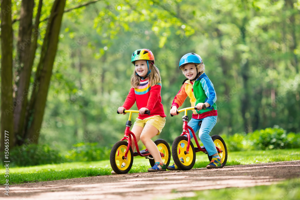 Kids ride balance bike in park Kids ride balance bike in park