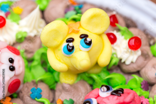 Celebration colorful cake decorated with fruit, chocolate and figures of animals for kids party