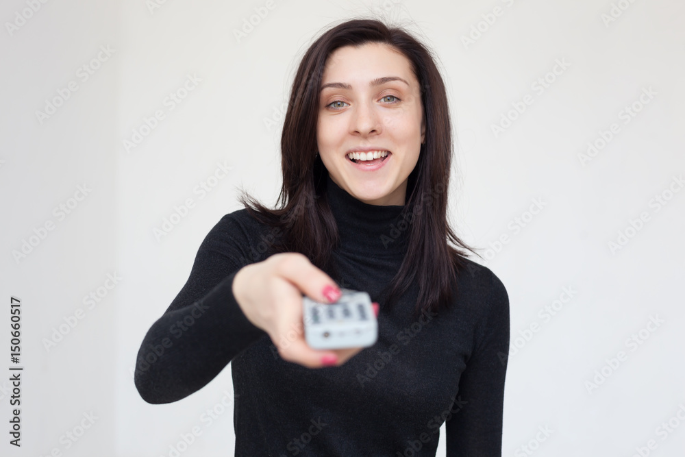 Girl changes TV program, pressing the button on the remote control Girl changes TV program, pressing the button on the remote control