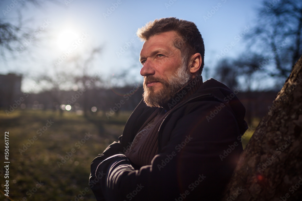 Portrait of an elderly man in a park. He looks thoughtfully into the distance, planning and dreaming about the future