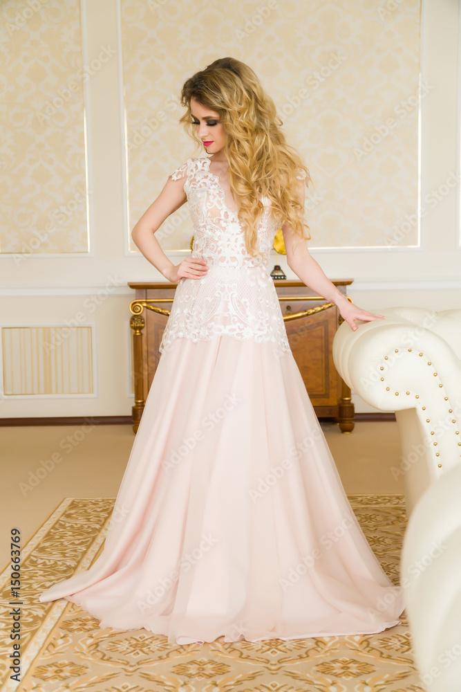 Portrait of beautiful young bride. A girl is posing in a hotel room. The lady is spinning in her wedding dress Portrait of beautiful young bride. A girl is posing in a hotel room. The lady is spinning in her wedding dress