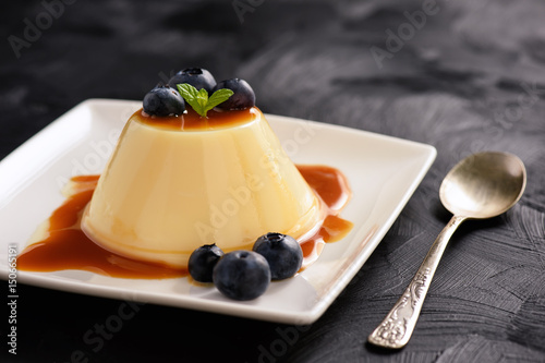 Cream pudding with caramel sauce and blueberries.