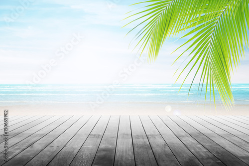 Empty wooden table and palm leafs with party on beach background blurred. Concept Summer  Beach  Sea  Relax  Party.