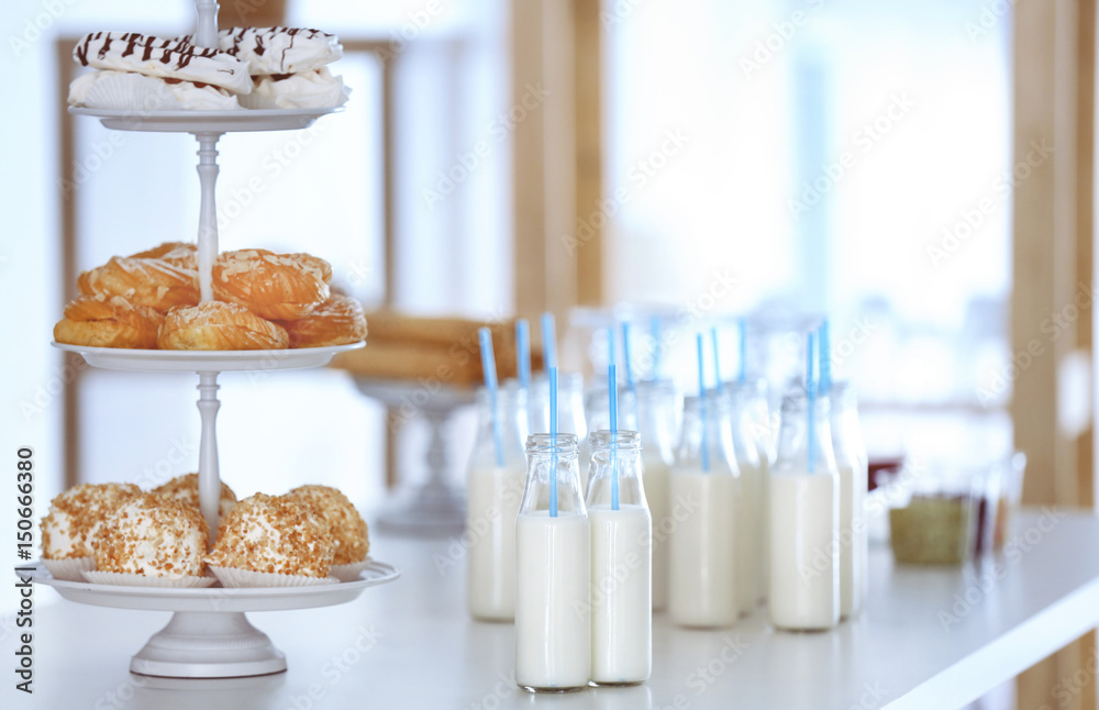 Table with bottles of milk and dessert stand
