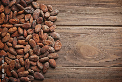 Aromatic cocoa beans on wooden background