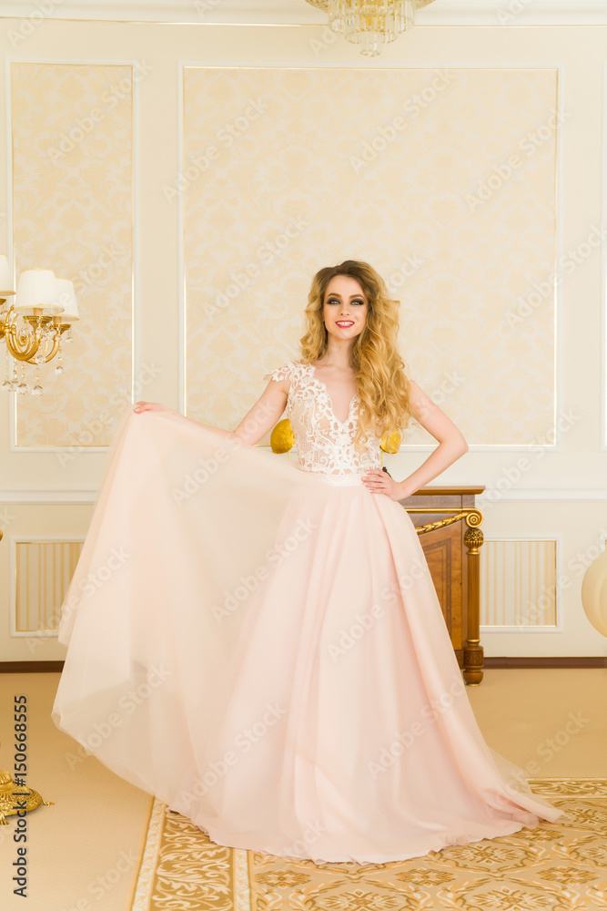 Portrait of beautiful young bride. A girl is posing in a hotel room. The lady is spinning in her wedding dress Portrait of beautiful young bride. A girl is posing in a hotel room. The lady is spinning in her wedding dress