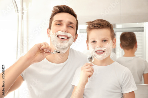 Father and son shaving in b...