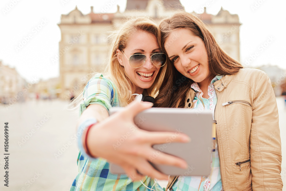 Young smiling women taking a selfie with tablet. Lifestyle, technology Young smiling women taking a selfie with tablet. Lifestyle, technology