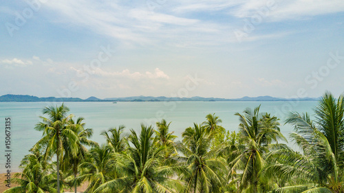 Beautiful Thai Island, sea view with blue sky above the palms, aerial panorama