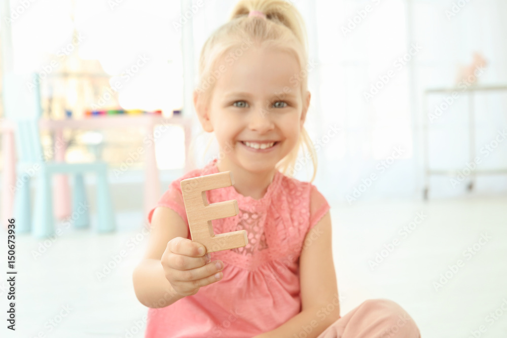 Cute little girl with letter E at home