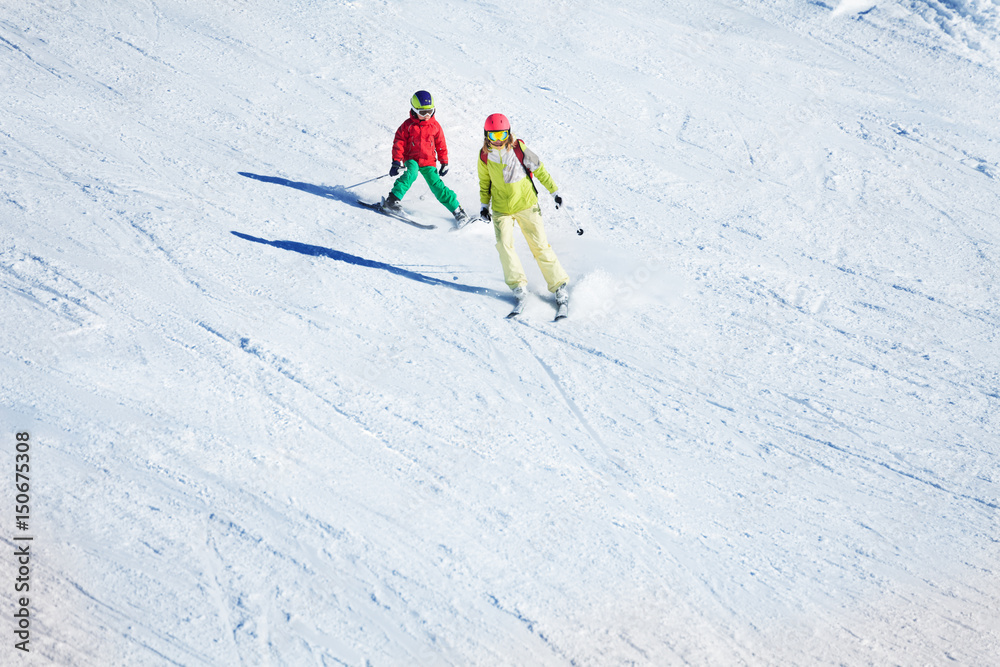 Two skiers hitting the slopes at snowy mountains