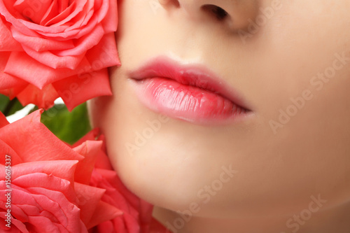 Face of beautiful young woman and roses  closeup