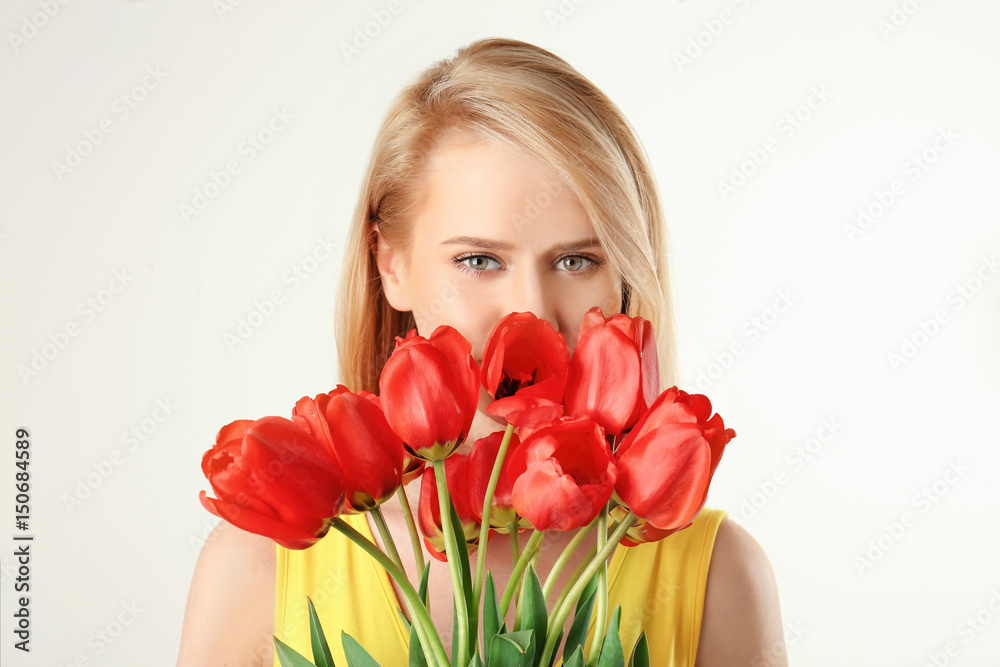 Beautiful young woman with bouquet of tulips on white background Beautiful young woman with bouquet of tulips on white background