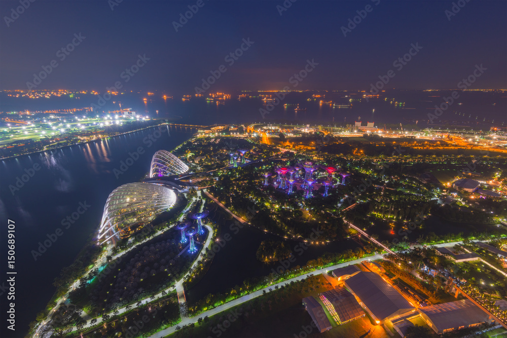 Naklejka premium Aerial view of Gardens by the bay by night, a nature park in central Singapore, part of a strategy by the Singapore government to transform Singapore from a Garden City to a City in a Garden.