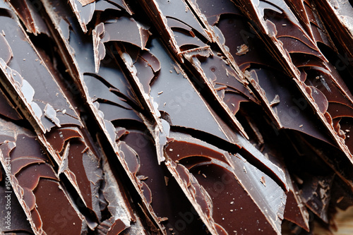 Close up of fine chocolate chopped by hand, sliced off the block with a knife.