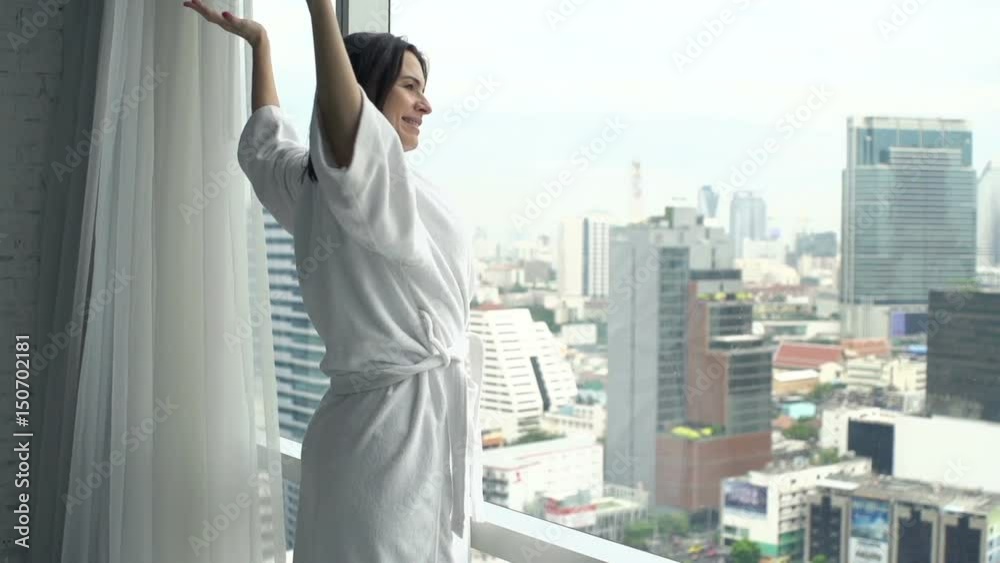 Woman in bathrobe stretching arms and admire view from window at home, super slow motion 120fps
Woman in bathrobe stretching arms and admire view from window at home, super slow motion 120fps