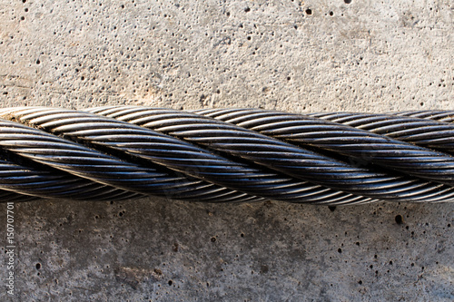 Photography Steel cable on a concrete surface close-up.