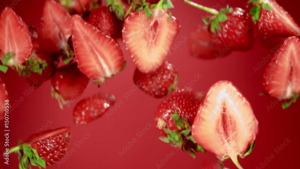 Ripe strawberrys flying in the air on a red background Ripe strawberrys flying in the air on a red background