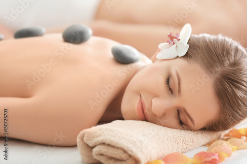 Young beautiful woman having stones massage in spa salon