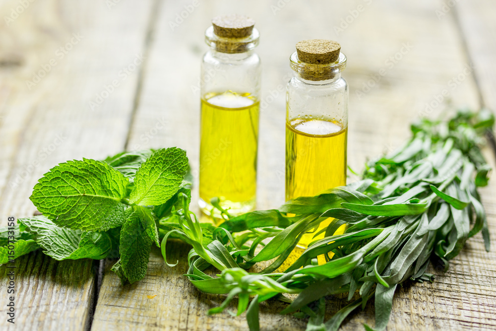 organic oil in bottle with mint on light table background organic oil in bottle with mint on light table background