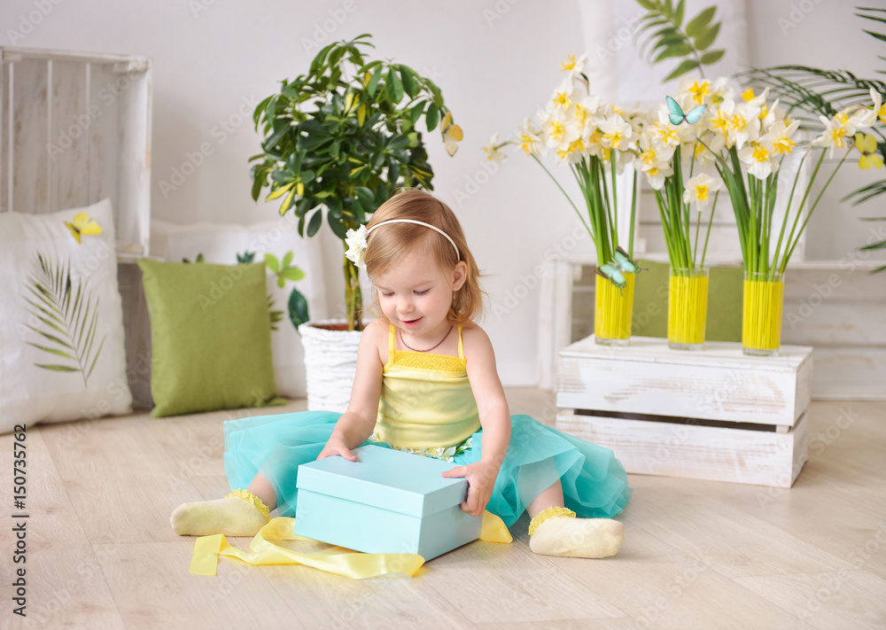 Beautiful little girl with gift box in a spring decor Beautiful little girl with gift box in a spring decor