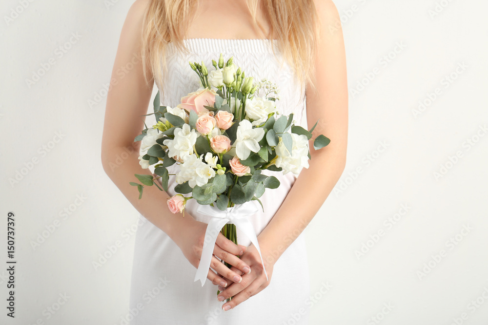 Beautiful bride holding bouquet with  freesia flowers on white background