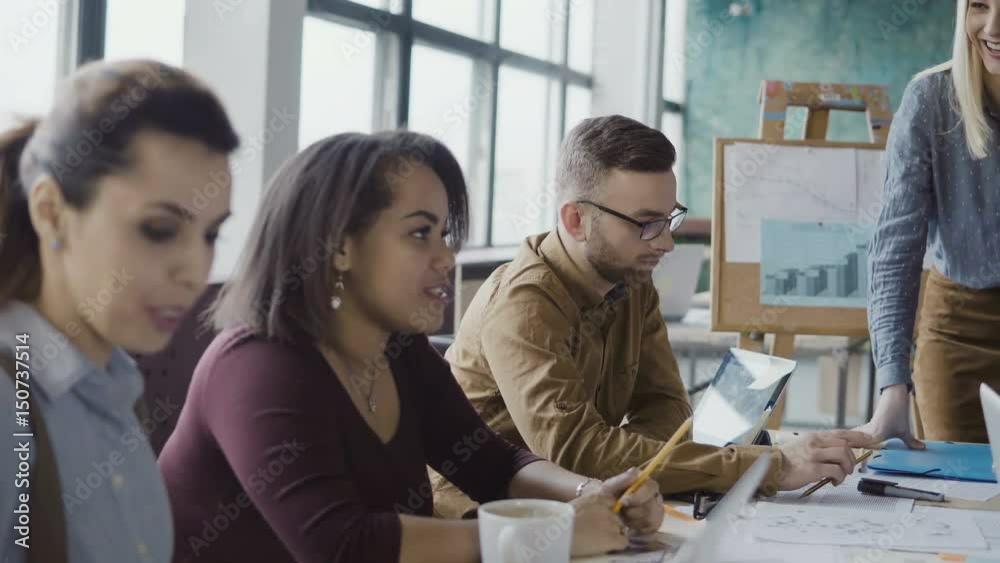 Business team meeting at modern office. Creative young mixed race group of people discussing new ideas with manager. Business team meeting at modern office. Creative young mixed race group of people discussing new ideas with manager.