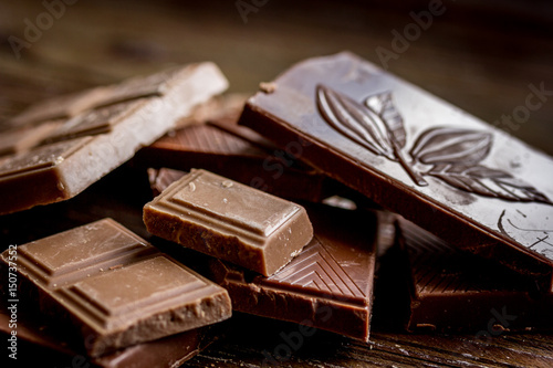 black and milk chocolate bars dark wooden table background