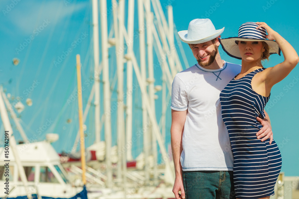 Tourist couple in marina against yachts in port