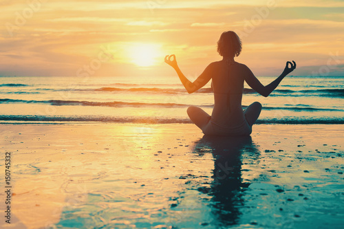Meditation girl on the sea during sunset. Yoga silhouette. © De Visu