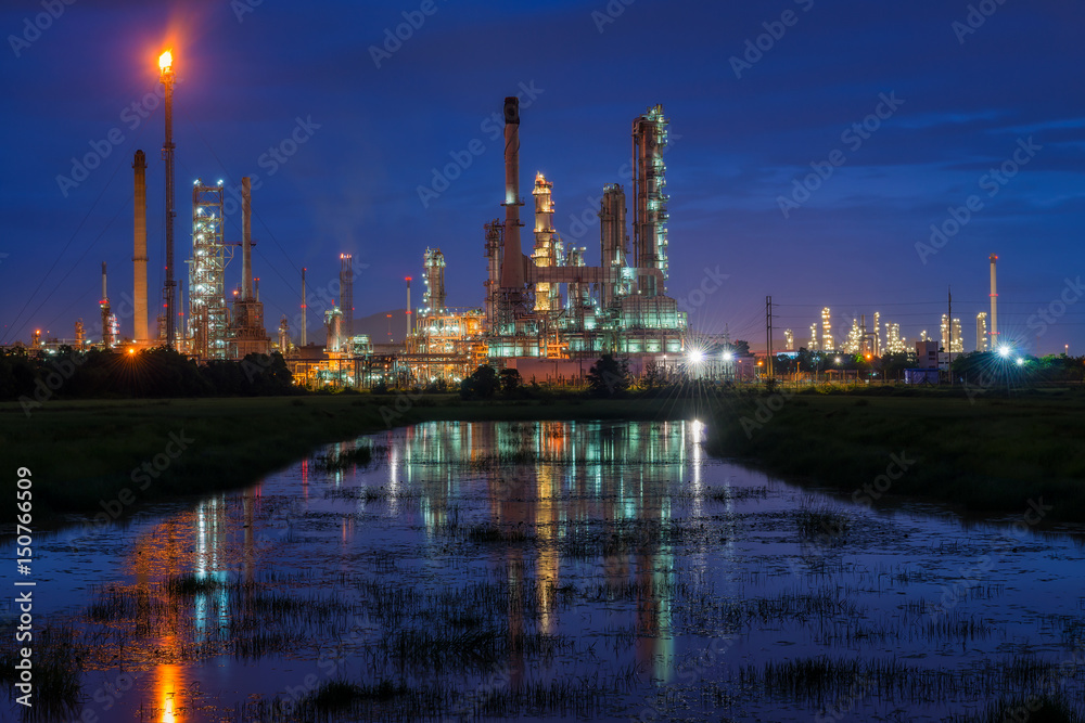 Oil refinery or petroleum refinery industry landscape with reflection at twilight time in the morning. Industrial estate of Thailand, industrial process plant where crude oil is processed and refined.