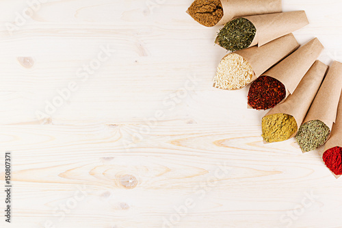 Oriental colorful powder condiments pattern as decorative border on white wooden board with copy space.