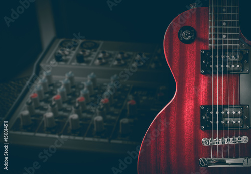 Red electric guitar and classic amplifier on a dark background