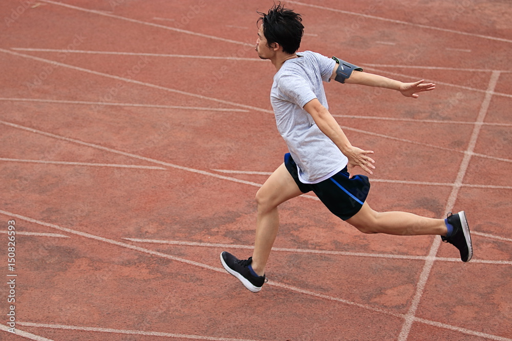 Obraz premium Athletic Asian runner sprinter crossing the finish line.