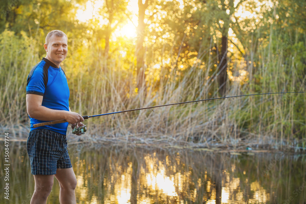 Fisherman with a spinning rod catching fish on a river. Fisherman with a spinning rod catching fish on a river.