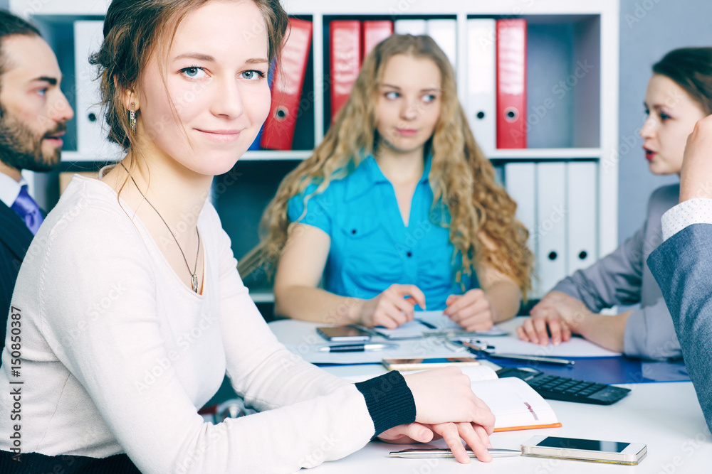 Female business leader sitting in front of her team. . Serious business and partnership concept. Female business leader sitting in front of her team. . Serious business and partnership concept.
