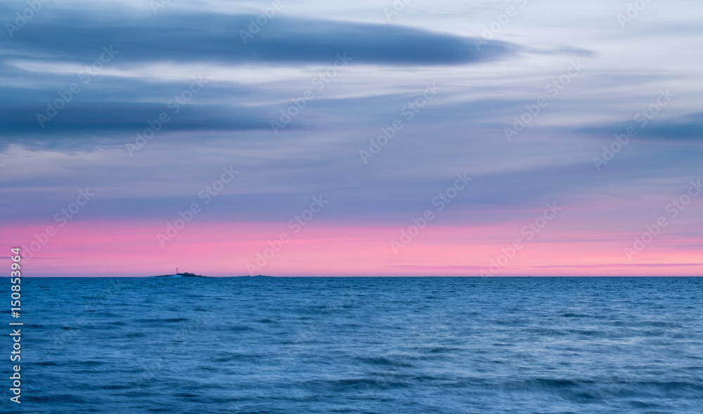 Seascape with sunset and pink horizon at winter evening